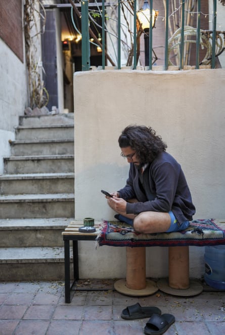 Mojtaba sits outside in his small, sheltered basement patio