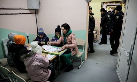 Children hide inside a bomb shelter near their school as part of police and security drills in Ozera village, Kyiv region.