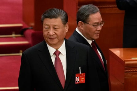 Chinese premier Li Qiang passes by president Xi Jinping as they attend the closing session of the National People’s Congress.