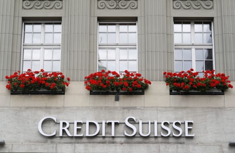 The logo of Swiss bank Credit Suisse is seen at a branch office in Bern beneath window planters of red flowers