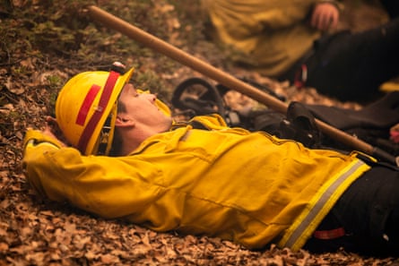 Rob Spitzer, a firefighter from Rancheria Station, rests in the smoldering forest after battling the Creek fire on 8 September.