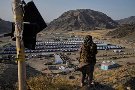 A Taliban fighter stands on a hill overlooking a camp housing Afghan refugees who have been repatriated from Pakistan, near the Pakistan-Afghanistan border, in Torkham, Afghanistan, May 31, 2025.