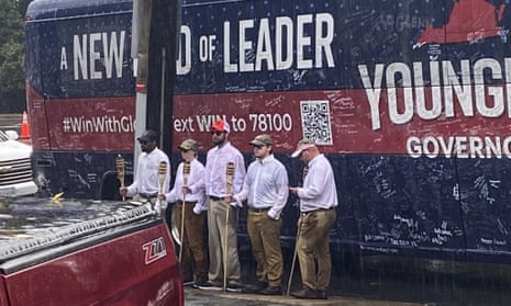 Five people holding tiki torches stand by the campaign bus for Glenn Youngkin in an image provided by NBC29.