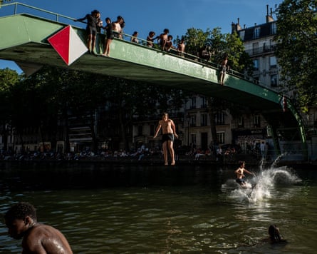 Children jumping off a bridge into a canal