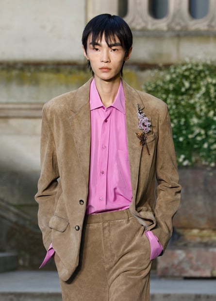 Model in beige suit and pink shirt and brooch