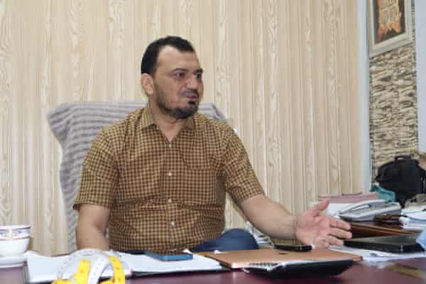 Nadeem Siddique, owner of Bismillah factory in Faisalabad, sitting at a desk.