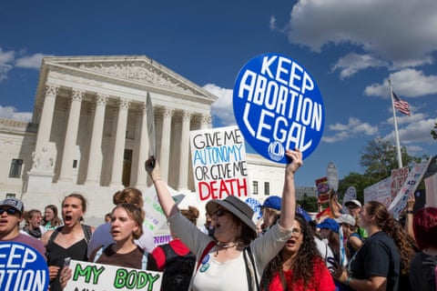 a person holds a sign that reads 'keep abortion legal'