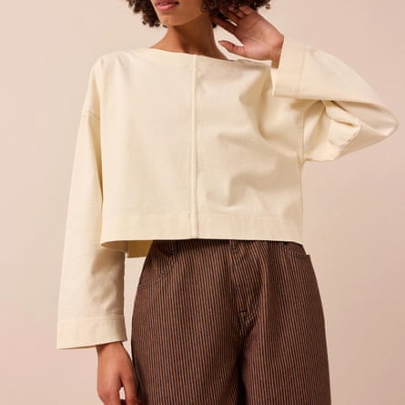 A model wears a Beyond Nine cream box top with brown trousers