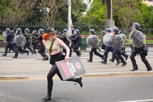 'Workers unite to fight the right' looks over her shoulder as she runs from riot police