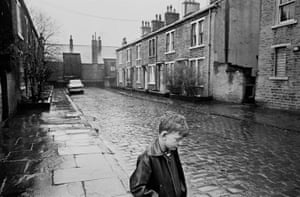 Bradford, 1969. A boy standing in the rain on Forster Steet