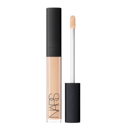 A concealer tube and wand. The concealer is white flesh tones. The lid is black. It is on a white background