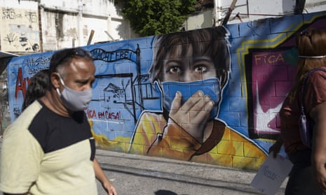 A man walks past a mural referencing the Covid-19 pandemic in Rio de Janeiro.