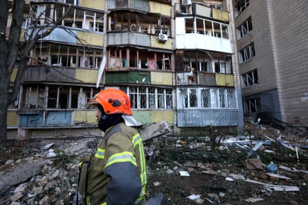 An emergency rescuer attends the scene at an apartment block in the Solomianskyi district, Kyiv.