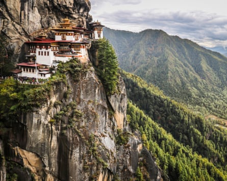 A monastery on a cliff overlooking a forest