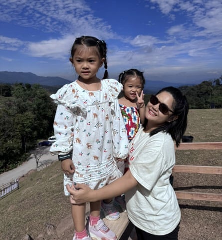 Pathanika Poonchai outside on a sunny day with her two young daughters