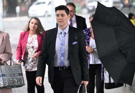 Jayde Struhs walks outdoors in a suit, arriving at court with others behind her