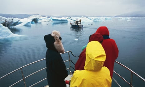 Tourists on bow of boat on a fjord in Greenland 