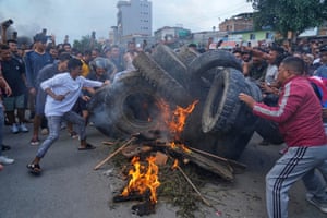 Chanting protesters throw tyres on to a bonfire