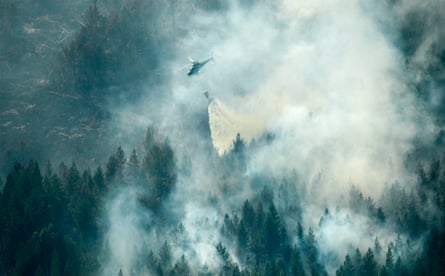 A firefighting helicopter drops water over the fire in Ljusdal, Sweden.