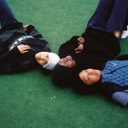 Les Hijabeuses (from left): Zamya, Diawara and Doucouré lie with heads together on the ground at Montreuil football pitch.
