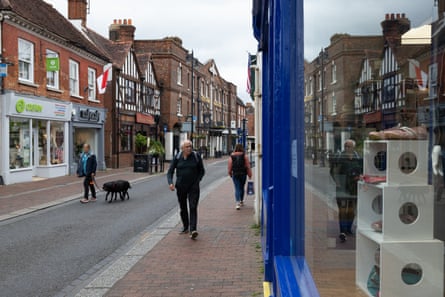 Three people walking along a street in Godalming town centre