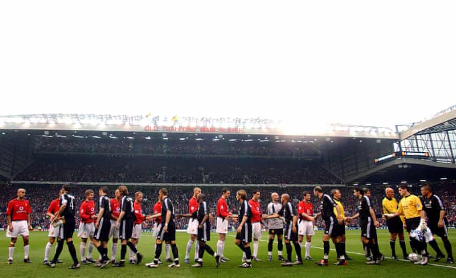 The players shake hands before kick-off at Old Trafford.
