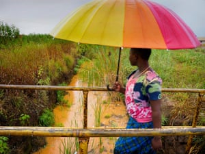 A villager crosses a canal carrying highly toxic water contaminated with lead and other mining byproducts through the neighborhood of Chowa in Kabwe, Zambia.