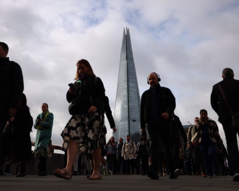 Commuters walk across London Bridge