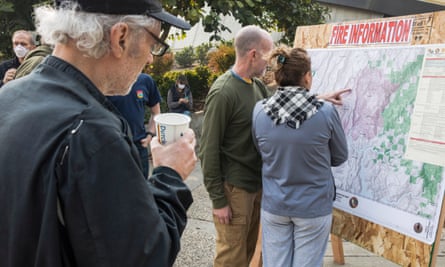 Residents locate their homes on a fire information map outlining the perimeter of the Camp Fire at the Neighborhood church evacuation shelter in Chico, California on 10 November.