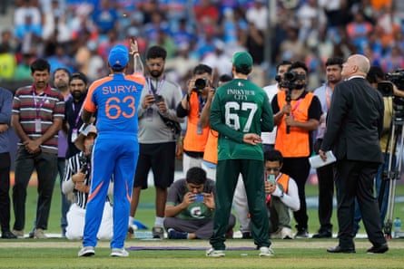 Pakistan’s Salman Agha watches as India’s Suryakumar Yadav flips the coin before their match in Dubai