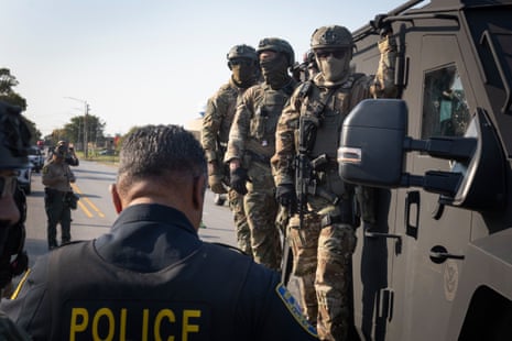 people in military uniforms stand on an armored vehicle