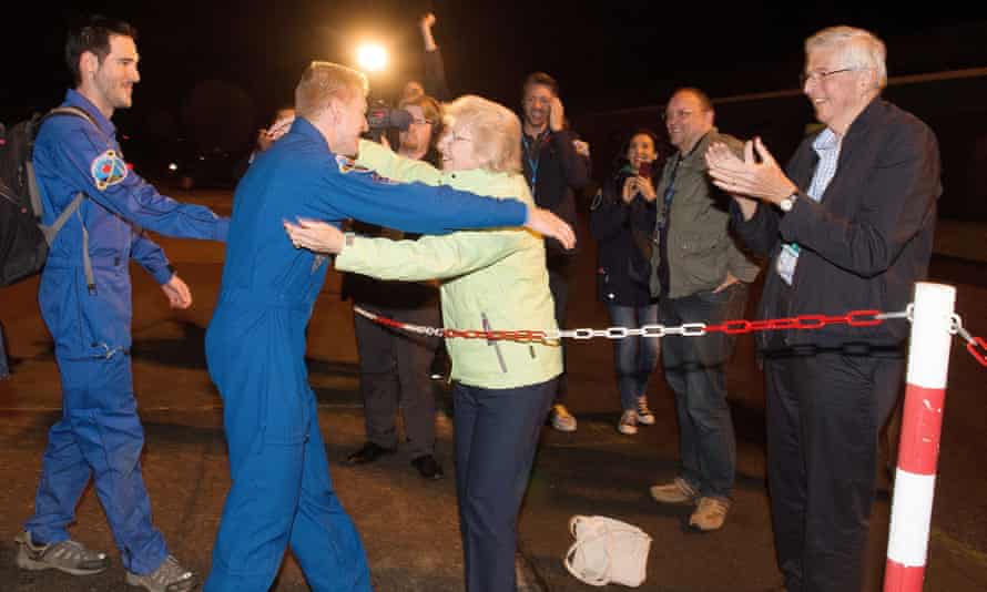 Peake (second left) greeting his mother Angela and father Nigel (right) as he arrives at Cologne airport.