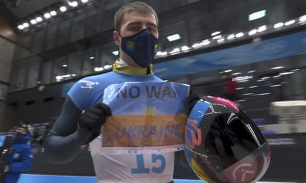Ukraine’s Vladyslav Heraskevych holds a sign at the 2022 Winter Olympics in Beijing.