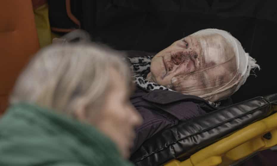 An injured woman evacuated from Irpin lies on a stretcher in an ambulance on the outskirts of Kyiv