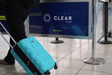 a person with a suitcase walks past a sign for 'Clear'
