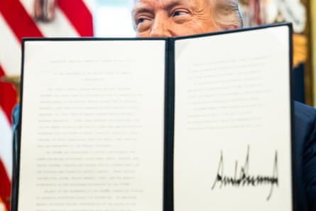 A sliver of Trump’s face can be seen behind a signed document