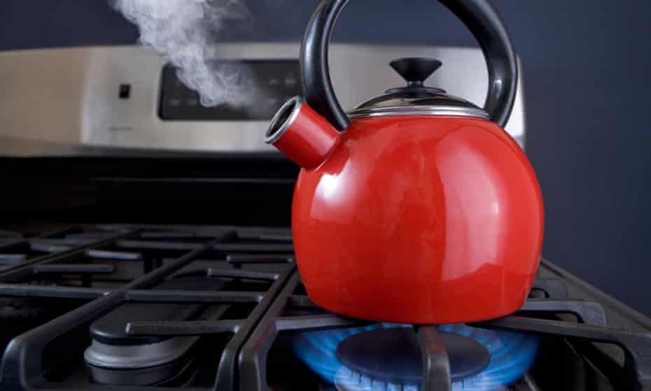 A red teapot is on the boil and steam is pouring out of the spout.