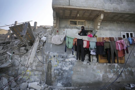 Palestinians among the debris of a destroyed building after Israeli attacks in Deir al-Balah.