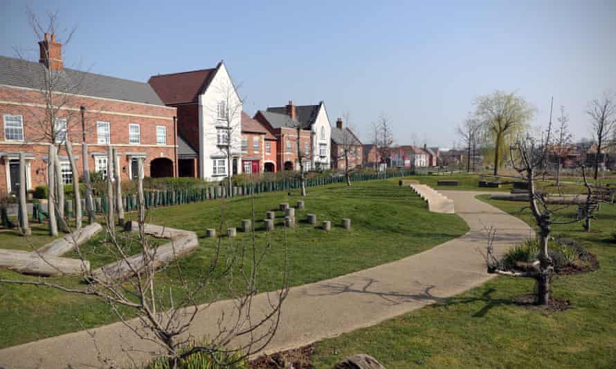 A row of new dwellings in various styles in front of a newly installed park with a wide walkway and young trees