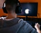 Anonymous young man sitting at his PC, playing computer games