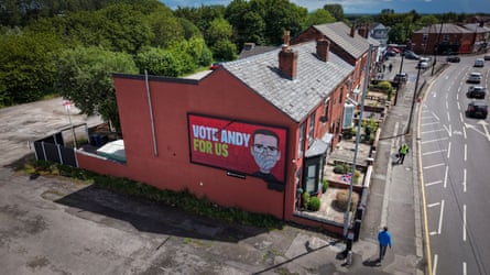 A video screen depicts Andy Burnham in Ashton-in-Makerfield on 10 June 2026.