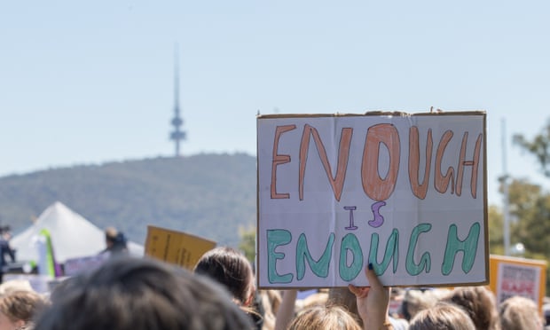 A sign reads 'enough is enough' at an anti-misogyny protest in front of the Parliament House in Canberra