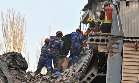 Rescuers carry the body of a person found at a site of a residential building heavily damaged by a recent Russian missile strike.