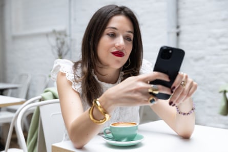 Olivia Petter on her phone in a cafe