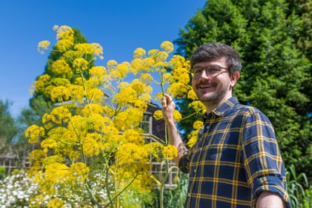 Matthew Jeffery standing next to a yellow shrub and trees