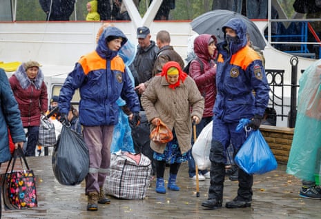 Civilians evacuated from the Russian-controlled city of Kherson walk from a ferry to board a bus heading to Crimea, in the town of Oleshky, Kherson region.