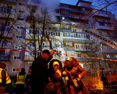 Neighbours assist an elderly woman to evacuate from a damaged apartment building hit during an overnight Russian drone and missile strike on Kyiv, Ukraine.