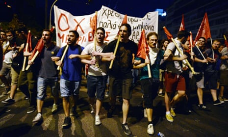 Protesters march, holding banners and flags in front of the Greek parliament in Athens during an anti-austerity protest