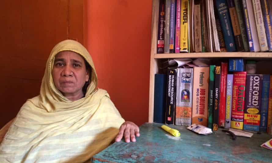 Halima Begum sits beside the books and desk of her son Muhammad Hafizur Rahman.