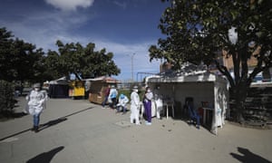Healthcare workers stand outside a tent set up to conduct nasal swab samples to test for Covid-19 in Bogota, Colombia.